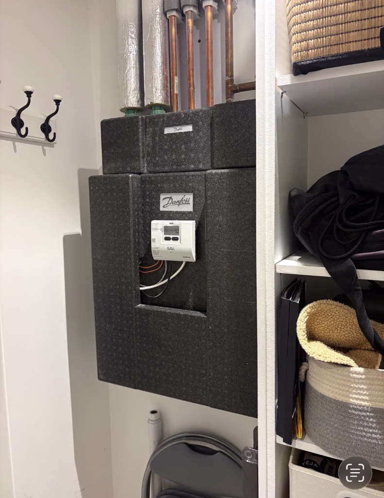 Danfoss HIU with insulated casing and copper pipework in a cupboard