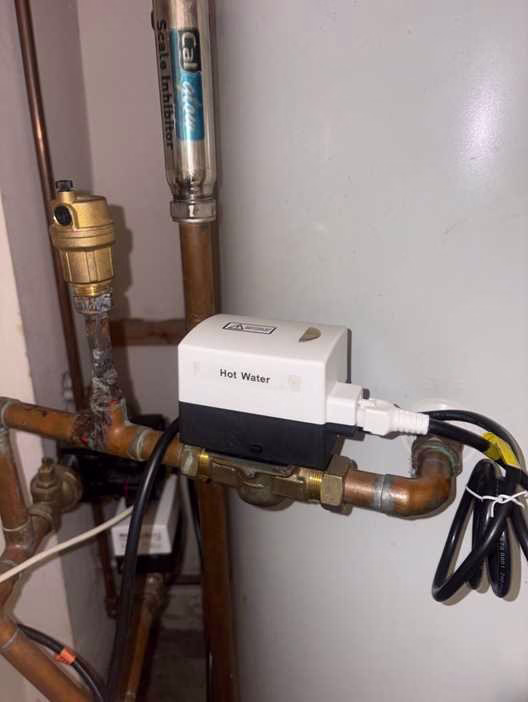 Newly fitted EPH 2-port motorised hot water zone valve on copper pipework in a Wimbledon heating cupboard